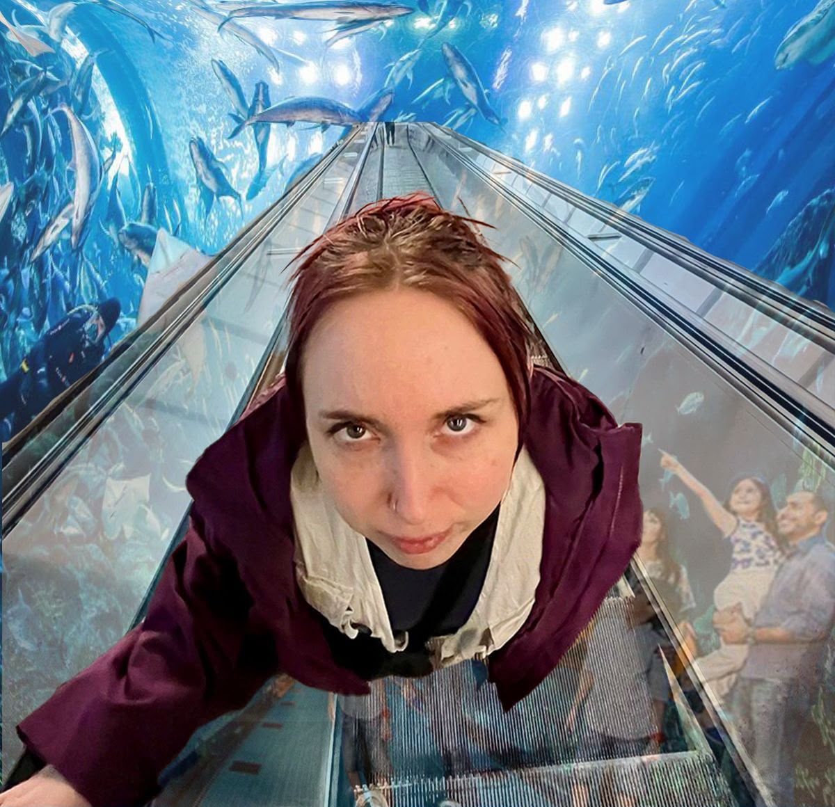 Shannon Brooke on an aquarium escalator surrounded by fish — 100 Million Fish in the Aquarium